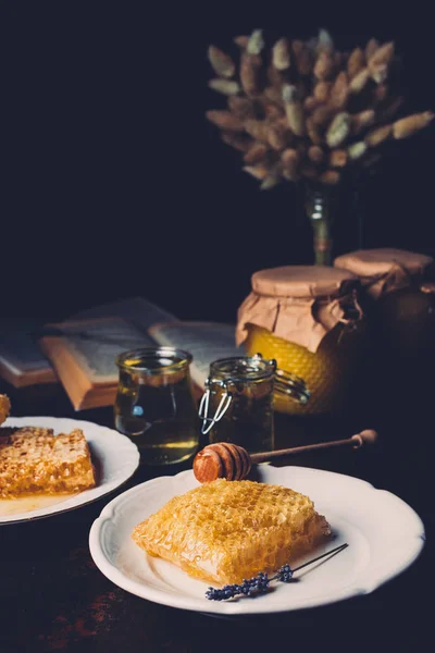 Selective focus of jars with honey, honeycombs and lavender on table — Stock Photo