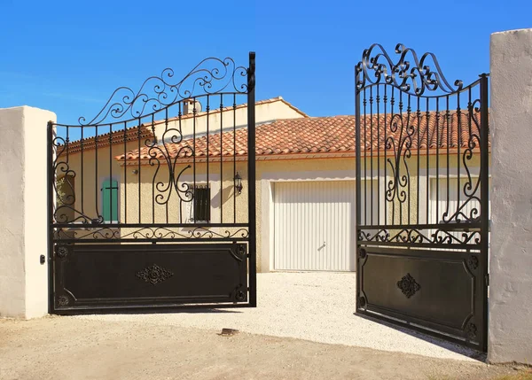 Ouverture otomatique d 'un portail de cloture de maison. Fer forge noir.                 