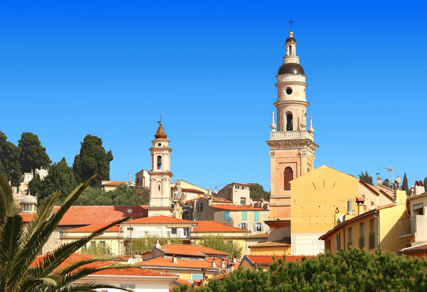 Колокольня базилики и крыши города Ментон во Франции
.