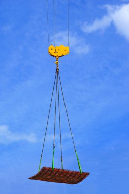 Hanging a load on the end of a hoist by means of slings.                      clipart