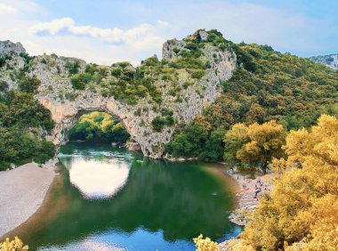 Fransa'da Pont d'Arc adlı doğal bir taş köprünün altında nağme ler.                   
