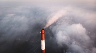 Fabrika borusunun tepesi sis ve hava fotoğrafçılığı yüzünden yükseliyor ve dikizliyor..