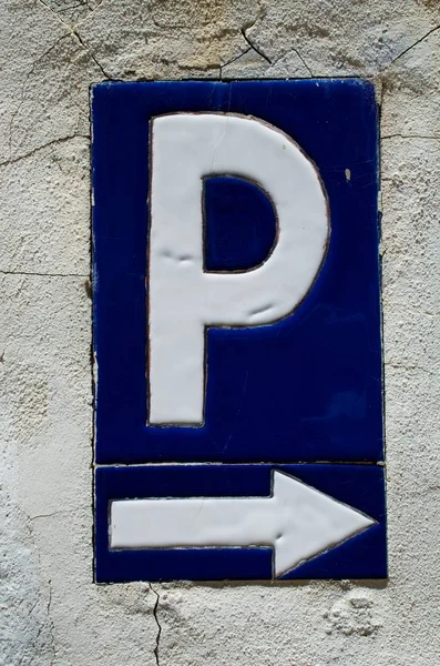 Old parking sign on a raw stone wall