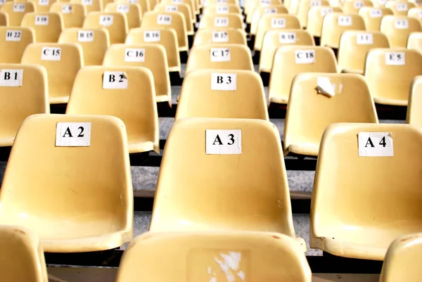 rows of seats with plastic chairs in a large arena