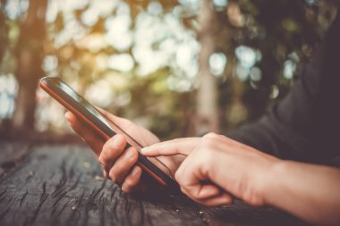 Kadın el iş, dağ manzarası doğa arka plan ile mali sosyal ağ smartphone veya tablet kullanarak