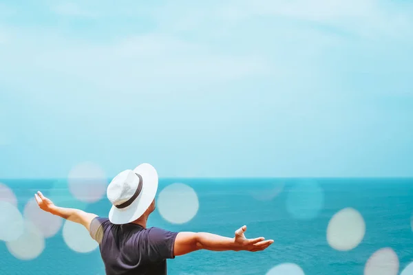 Man rise hands up to sky freedom concept with blue sky and summer beach background.