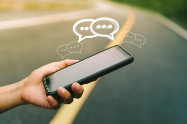 Kadınlar akıllı telefon daktiloyla yazı yazıp sohbet ediyorlar. Sohbet kutusu simgeleri ortaya çıkıyor. Sosyal medya teknolojisi kavramı. Klasik yumuşak renk tonu arkaplanı.