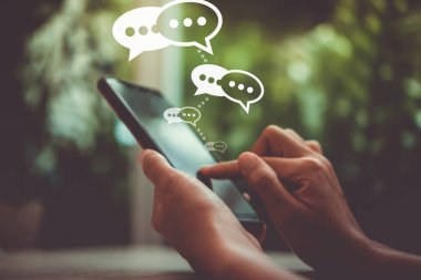 Kadınlar akıllı telefon daktiloyla yazı yazıp sohbet ediyorlar. Sohbet kutusu simgeleri ortaya çıkıyor. Sosyal medya teknolojisi kavramı. Klasik yumuşak renk tonu arkaplanı.
