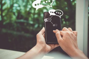 Kadınlar akıllı telefon daktiloyla yazı yazıp sohbet ediyorlar. Sohbet kutusu simgeleri ortaya çıkıyor. Sosyal medya teknolojisi kavramı. Klasik yumuşak renk tonu arkaplanı.
