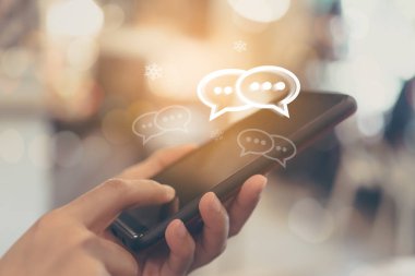 Kadınlar akıllı telefon daktiloyla yazı yazıp sohbet ediyorlar. Sohbet kutusu simgeleri ortaya çıkıyor. Sosyal medya teknolojisi kavramı. Klasik yumuşak renk tonu arkaplanı.