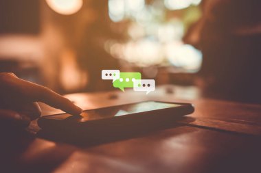 Kadınlar akıllı telefon daktiloyla yazı yazıp sohbet ediyorlar. Sohbet kutusu simgeleri ortaya çıkıyor. Sosyal medya teknolojisi kavramı. Klasik yumuşak renk tonu arkaplanı.