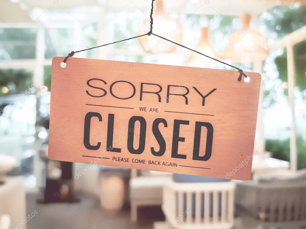 Sorry we are closed sign hang on door at coffee shop.