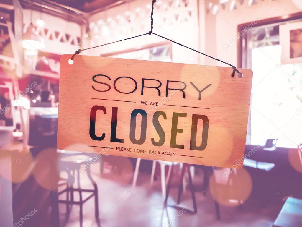 Sorry we are closed sign hang on door at coffee shop.