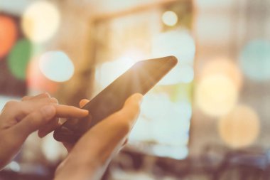 Kadın el Smartphone ve dizüstü bilgisayar ile kafeterya salonu renkli güzel bokeh arka plan kullanarak. İş, finans, Ticaret hisse senedi maket ve sosyal ağ kavramı.