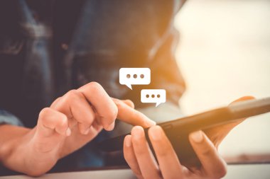 Kadınlar akıllı telefon daktiloyla yazı yazıp sohbet ediyorlar. Sohbet kutusu simgeleri ortaya çıkıyor. Sosyal medya teknolojisi kavramı. Klasik yumuşak renk tonu arkaplanı.