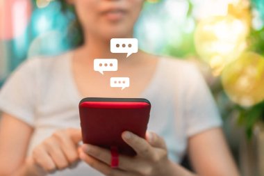 Kadınlar akıllı telefon daktiloyla yazı yazıp sohbet ediyorlar. Sohbet kutusu simgeleri ortaya çıkıyor. Sosyal medya teknolojisi kavramı. Klasik yumuşak renk tonu arkaplanı.