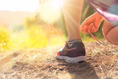 Kadın, yeşil arka planda yürürken ve koşarken koşu ayakkabısı giyer. Sağlık egzersizi konsepti..