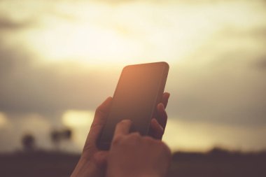 Kadın el doğa ile Smartphone kullanarak yeşil güzel arka plan. İş, finans, Ticaret hisse senedi maket ve sosyal ağ kavramı.