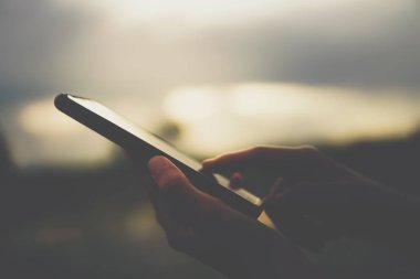 Kadın el doğa ile Smartphone kullanarak yeşil güzel arka plan. İş, finans, Ticaret hisse senedi maket ve sosyal ağ kavramı.