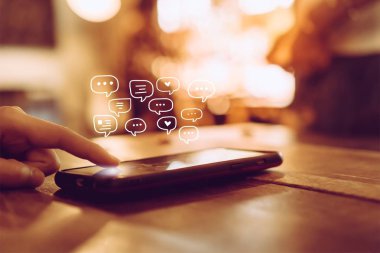 Kadınlar akıllı telefon daktiloyla yazı yazıp sohbet ediyorlar. Sohbet kutusu simgeleri ortaya çıkıyor. Sosyal medya teknolojisi kavramı. Klasik yumuşak renk tonu arkaplanı.