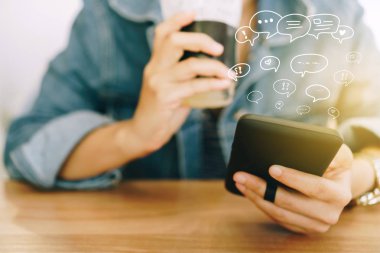 Kadınlar akıllı telefon daktiloyla yazı yazıp sohbet ediyorlar. Sohbet kutusu simgeleri ortaya çıkıyor. Sosyal medya teknolojisi kavramı. Klasik yumuşak renk tonu arkaplanı.