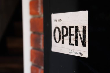 Açık kapı girişinde Vintage renk tonu tarzı kafe ya da restoran bekle diyor bir iş işareti.