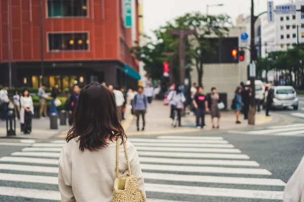 女性が横断歩道で信号を待ってください — ストック写真