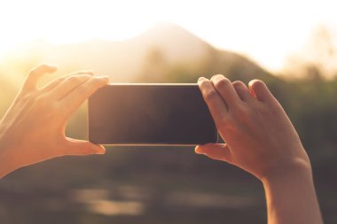 Kadın el smartphone fotoğraf makinesinden alınan fotoğraf güzel doğa görünümü arka plan için al.