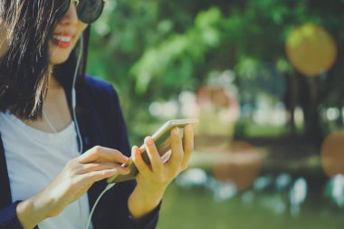 Kadın el Smartphone ve gülümseme kullanarak eğlenceli doğa ile hissediyorum güzel arka plan. İş, finans, Ticaret hisse senedi maket ve sosyal ağ kavramı.