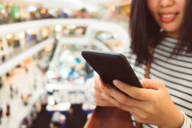 Kadın el Smartphone ve gülümseme kullanarak eğlenceli doğa ile hissediyorum güzel arka plan. İş, finans, Ticaret hisse senedi maket ve sosyal ağ kavramı.