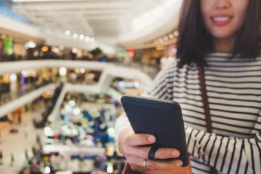 Kadın el Smartphone ve gülümseme kullanarak eğlenceli doğa ile hissediyorum güzel arka plan. İş, finans, Ticaret hisse senedi maket ve sosyal ağ kavramı.