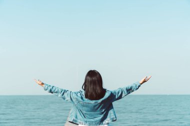 Kadın gökyüzü özgürlük kavramına el kaldırır mavi gökyüzü ve yaz arkaplanı ile.