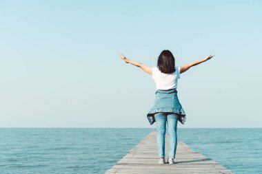 Kadın gökyüzü özgürlük kavramına el kaldırır mavi gökyüzü ve yaz arkaplanı ile.