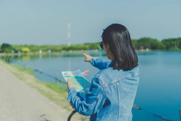 旅行マップの背景を見て 自然に小さな道で女性に乗る自転車 — ストック写真