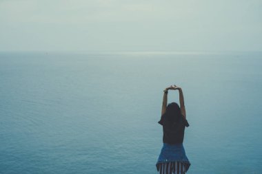 Kadın gökyüzü özgürlük kavramına el kaldırır mavi gökyüzü ve yaz arkaplanı ile.