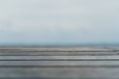 Ürününüzü göstermek için güzel plaj arka planına sahip eski ahşap masanın seçici odağı. 