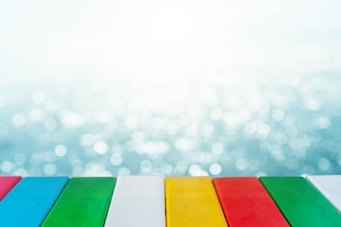 Ürününüzü göstermek için güzel plaj arka planına sahip eski ahşap masanın seçici odağı. 