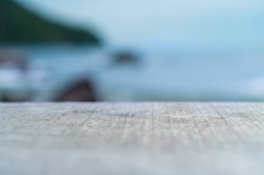 Ürününüzü göstermek için güzel plaj arka planına sahip eski ahşap masanın seçici odağı. 