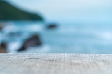 Ürününüzü göstermek için güzel plaj arka planına sahip eski ahşap masanın seçici odağı. 