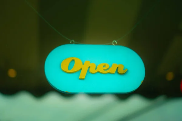 A business sign that says open on cafe or restaurant hang on door at entrance. Vintage color tone style.