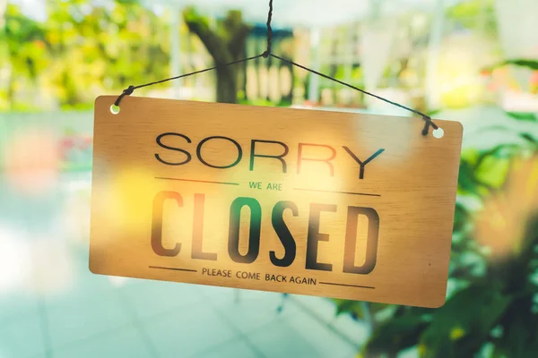 Sorry we are closed sign hang on door at coffee shop.