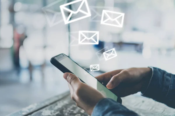 Woman hand using smartphone to send and recieve email for business on bokeh vintage color tone background.