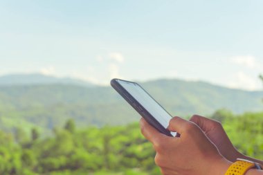 Kadın el doğa ile Smartphone kullanarak yeşil güzel arka plan. İş, finans, Ticaret hisse senedi maket ve sosyal ağ kavramı.