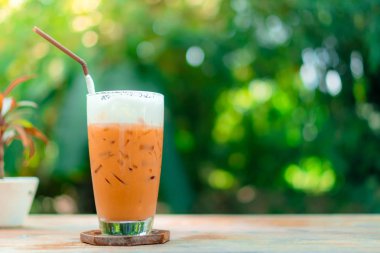 Buz çay chai latte film vintage sesi ve yeşil bokeh arka plan ile tabloda sütlü.