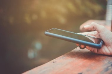 Kadın el Smartphone ile kafeterya salonu renkli güzel bokeh arka plan kullanarak. İş, finans, Ticaret hisse senedi maket ve sosyal ağ kavramı.