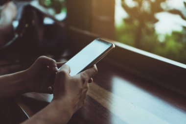 Kadın el Smartphone ile kafeterya salonu renkli güzel bokeh arka plan kullanarak. İş, finans, Ticaret hisse senedi maket ve sosyal ağ kavramı.