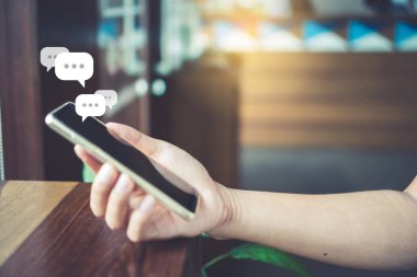 Kadınlar akıllı telefon daktiloyla yazı yazıp sohbet ediyorlar. Sohbet kutusu simgeleri ortaya çıkıyor. Sosyal medya teknolojisi kavramı. Klasik yumuşak renk tonu arkaplanı.