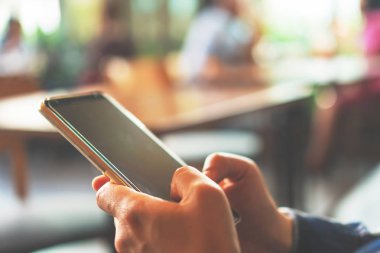 Kadın el kafe salonu arka planda Smartphone kullanarak. İş, finans, Ticaret hisse senedi maket ve sosyal ağ kavramı.