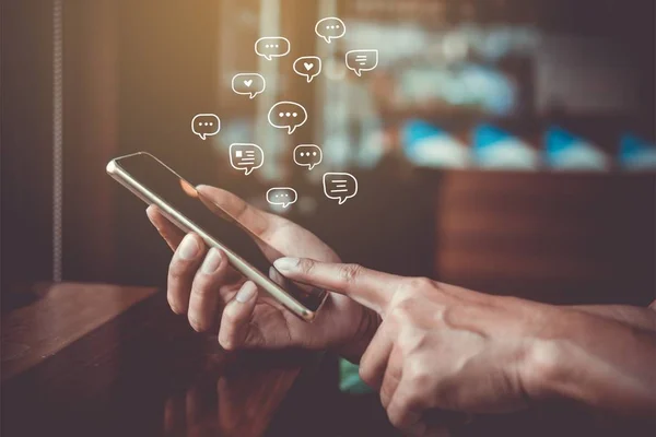 Kadın el yazarak, smartphone kullanarak sohbet sohbet sohbet kutusu simgeleri açılır. Sosyal medya pazarlama kavramı.