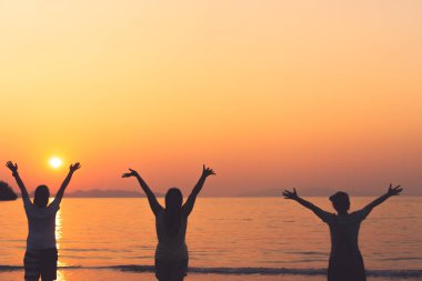 Kadının bir grup gökyüzü özgürlük kavramı mavi gökyüzü ve plaj arka plan ile kadar eller yükselişi.